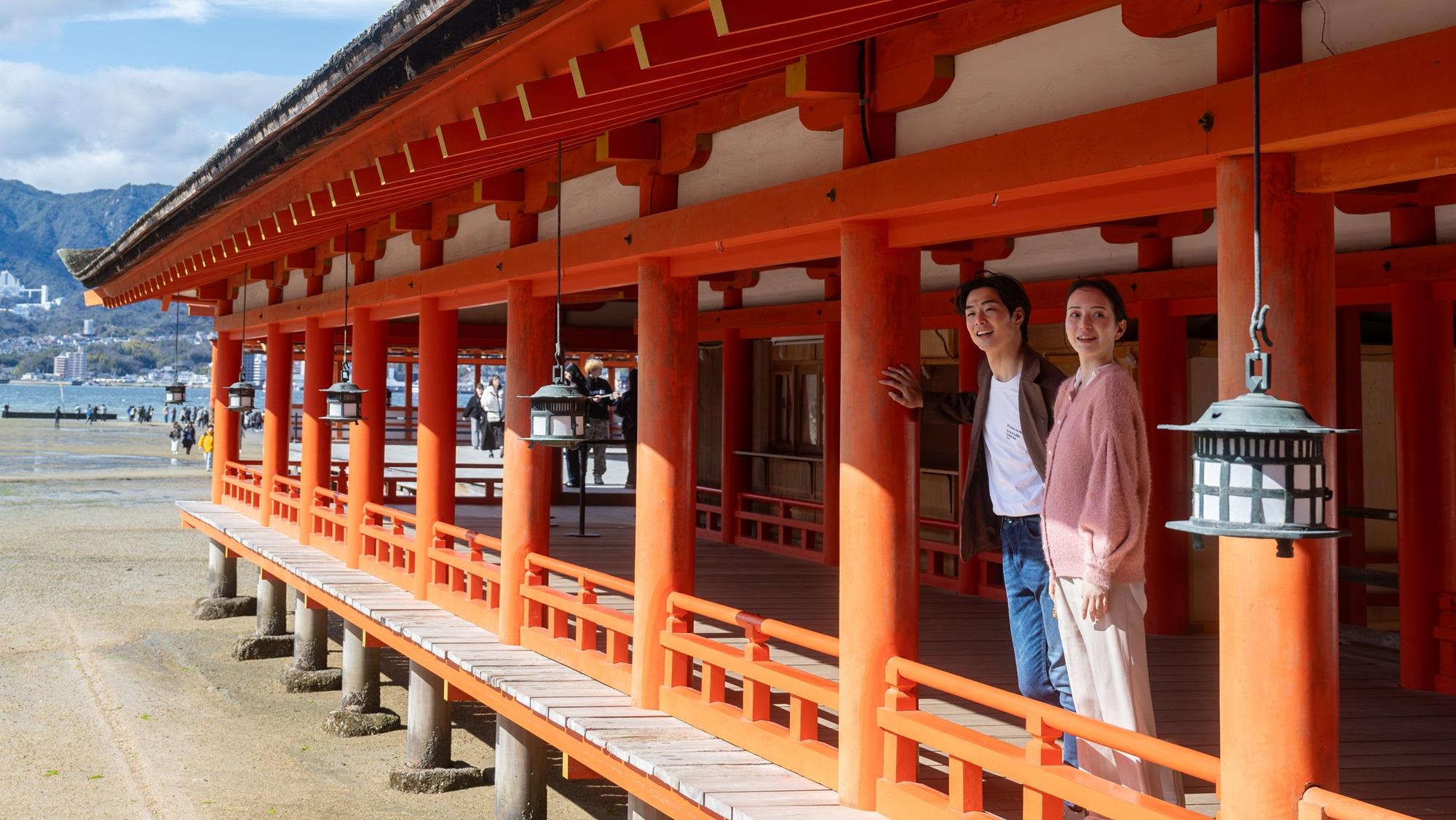 世界遺産嚴島神社をカップルが歩いている