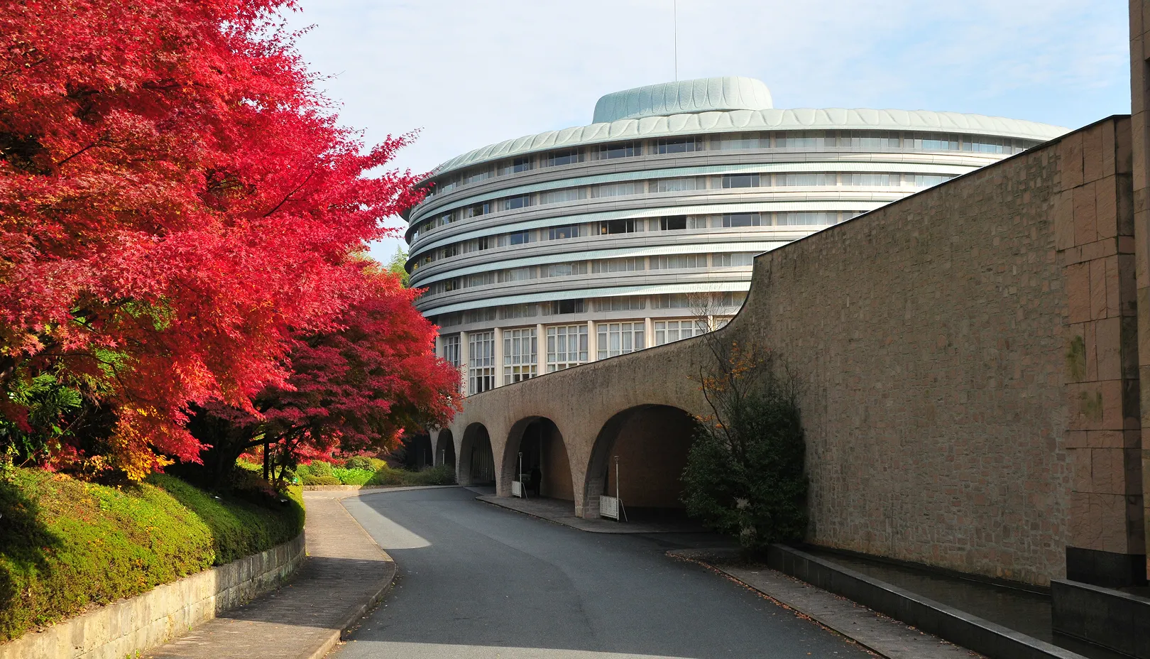 紅葉に彩られた円形のホテル棟
