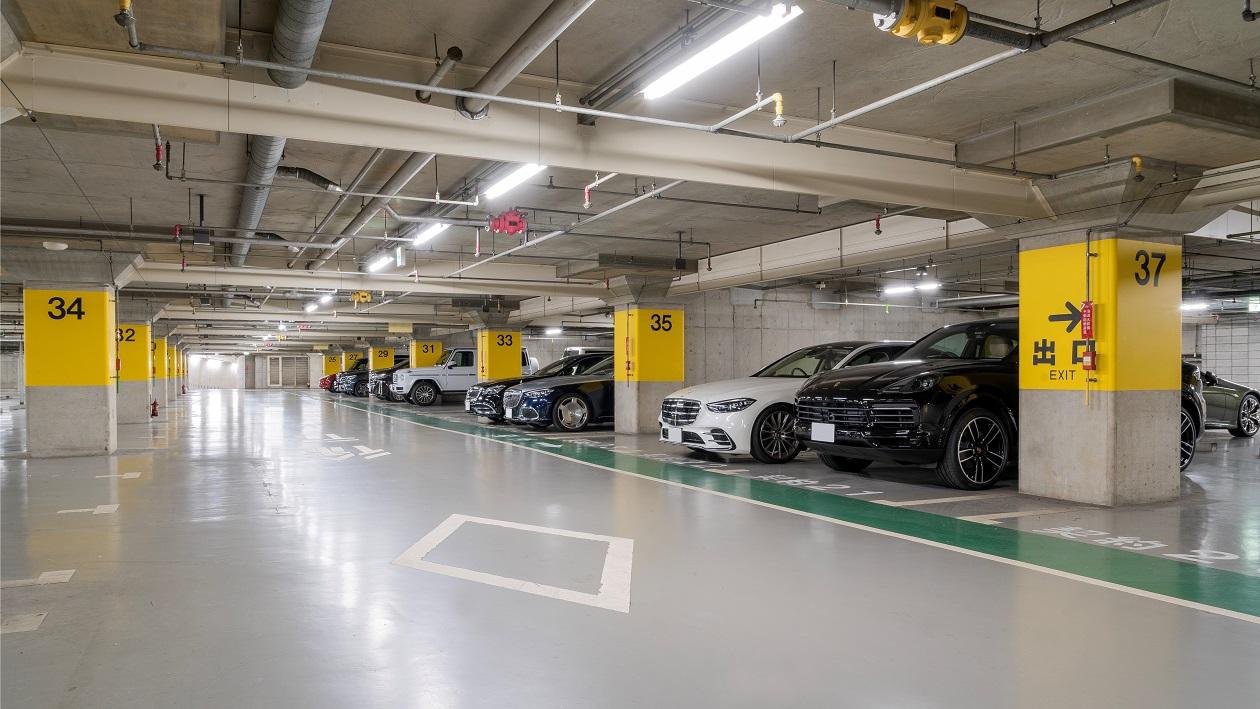 ホテルの地下駐車場に車が数台止まっている風景。